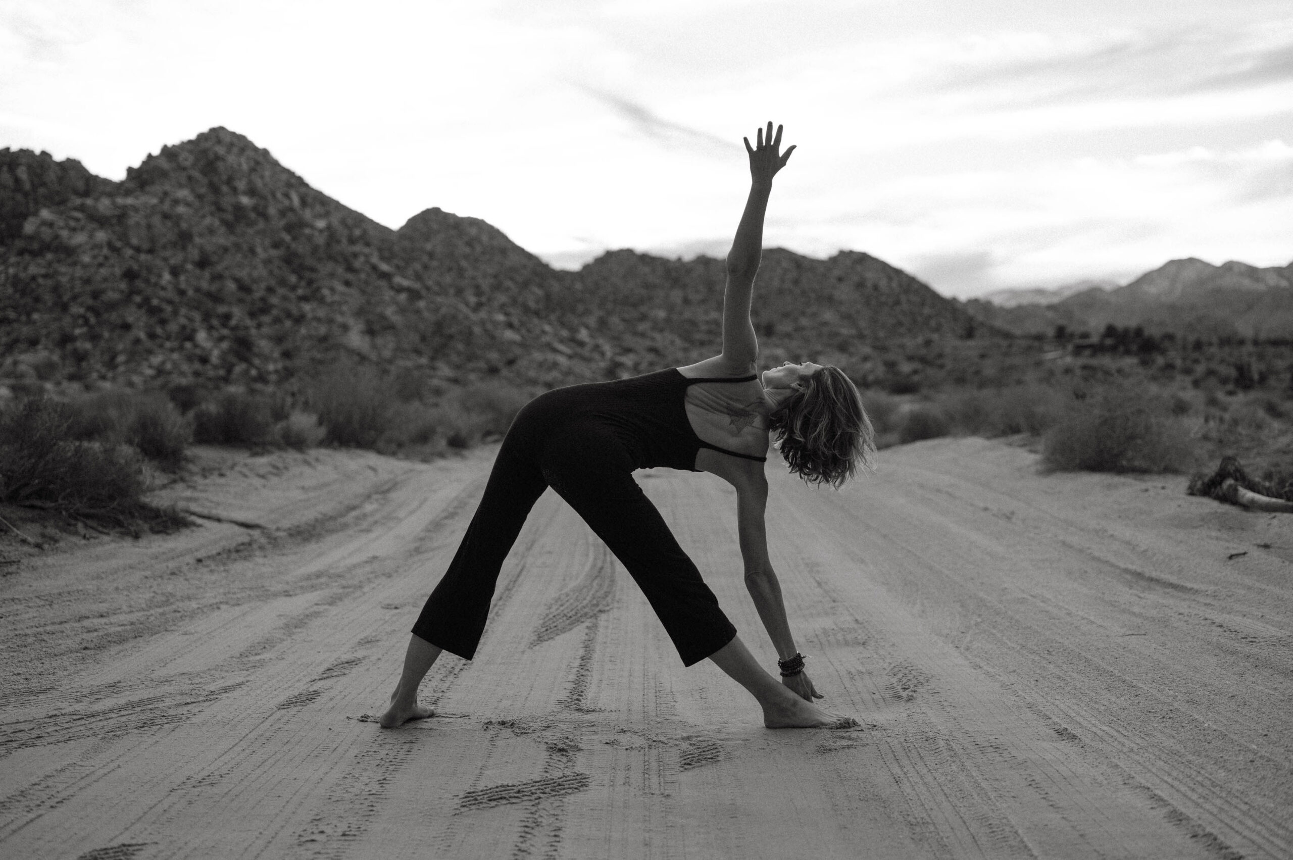 a woman doing a yoga pose on a dirt road | centerforrisingminds.org