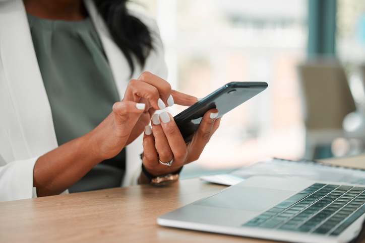 Person using phone and laptop at the same time, illustrating distraction and overwhelm common with ADHD and anxiety